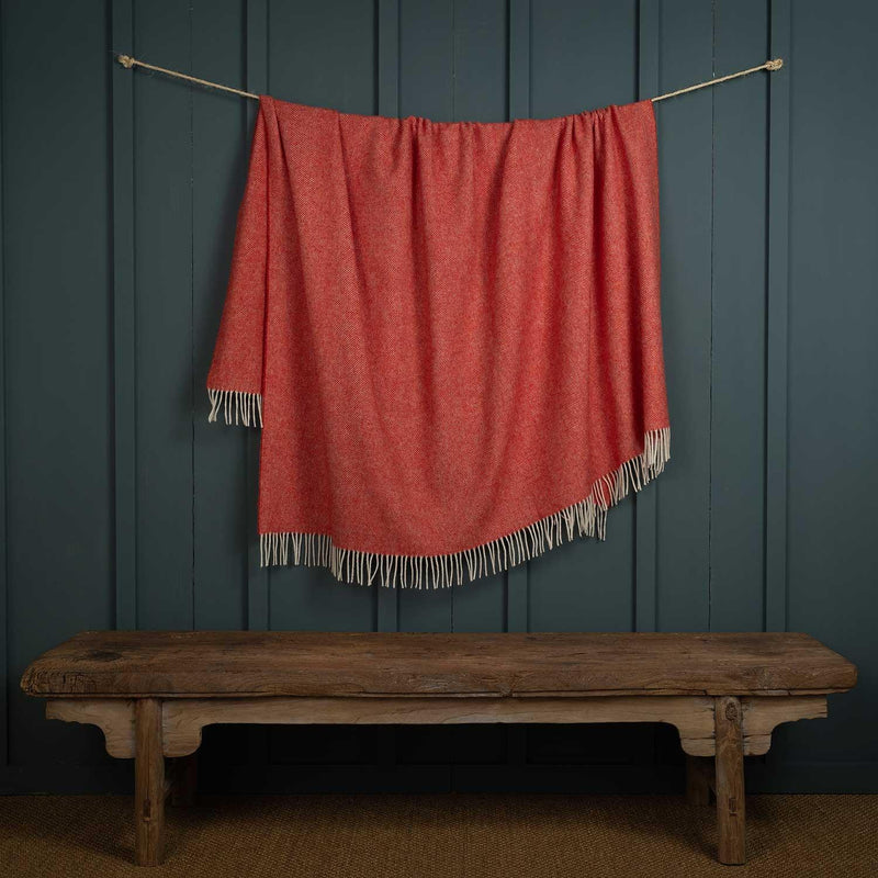 Shetland wool herringbone throw in coral red, a bright soft throw with a cream fringe, size is 140 CMS by 185 CMS.