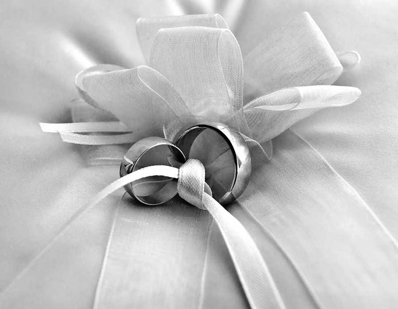 Two wedding rings tied together with a satin ribbon