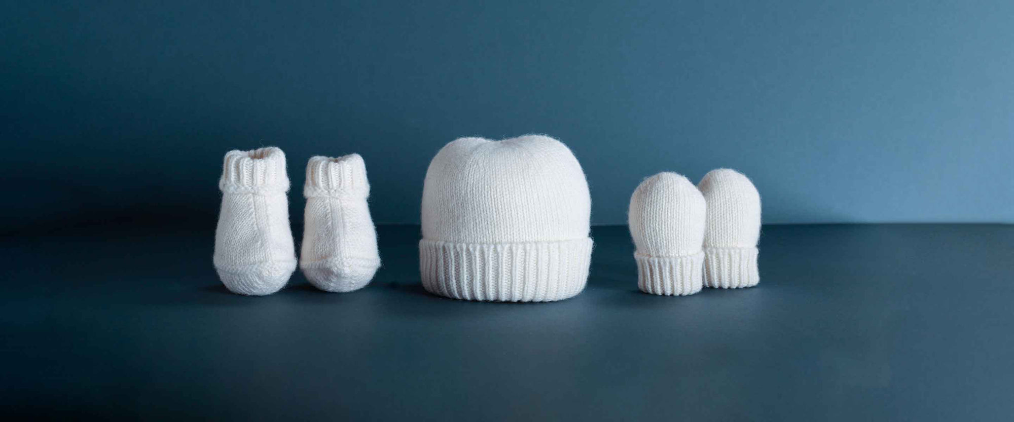 Gorgeous pure 100% Mongolian cashmere booties, mittens, beanie hats, and stunning blankets knitted in ivory in Scotland.