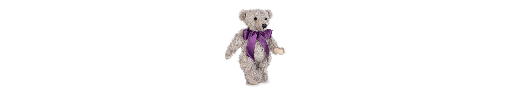 Chester teddy bear in his purple bow, stands at 12 inches tall. Fully jointed; soft grey mohair, with light stone felt paws.