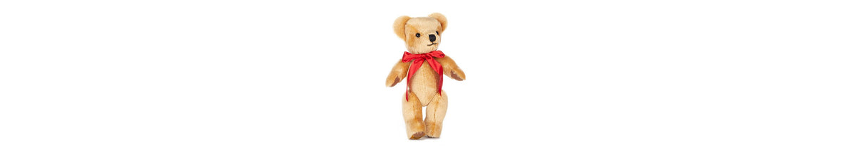  London Gold handsome in his red bow, stands at 12 inches tall. Fully jointed; soft golden mohair, with oak-brown felt paws.