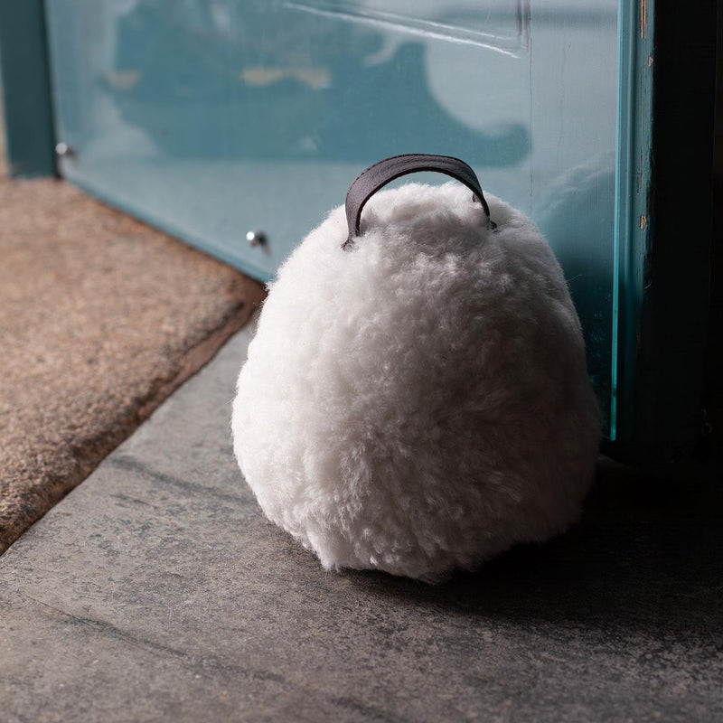 Sheepskin Doorstop in white curly sheepskin with dark brown leather carry handle