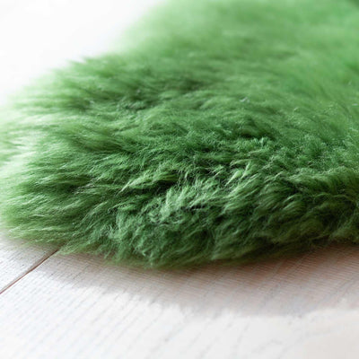Sheepskin rug in bright green, close-up photo.