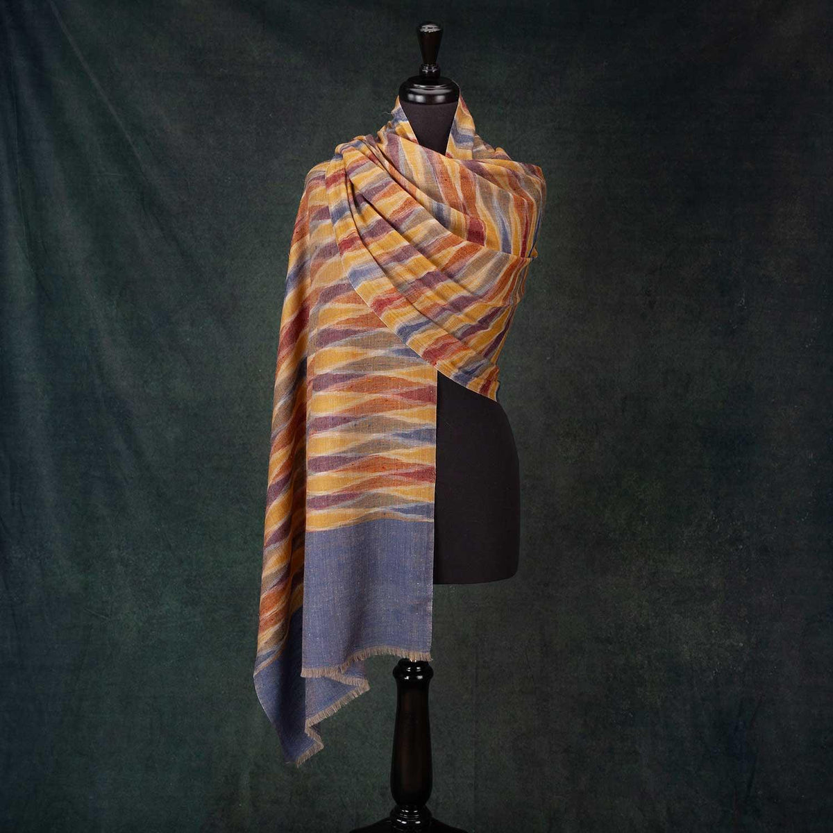 Amazingly soft Ikat shawl woven with a wide blue border at each end and a playfully colourful zigzag pattern of blues, reds, and yellows, creating a rainbow of colour through the main body. 70 x 200 CMS.