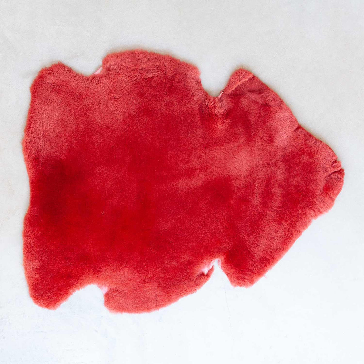 red sheepskin, short and soft fleece, average size is 115 CMS X 70 CMS.