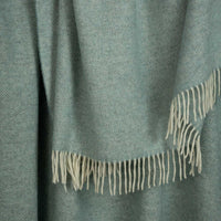 Shetland Wool Throw in Duck Egg Green colour, herringbone pattern with fringe, close up.