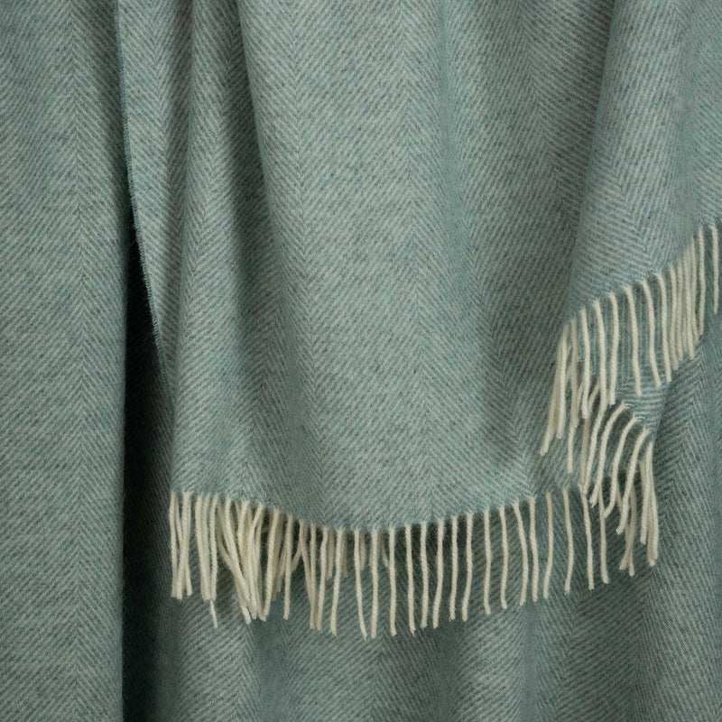 Shetland Wool Throw in Duck Egg Green colour, herringbone pattern with fringe, close up.