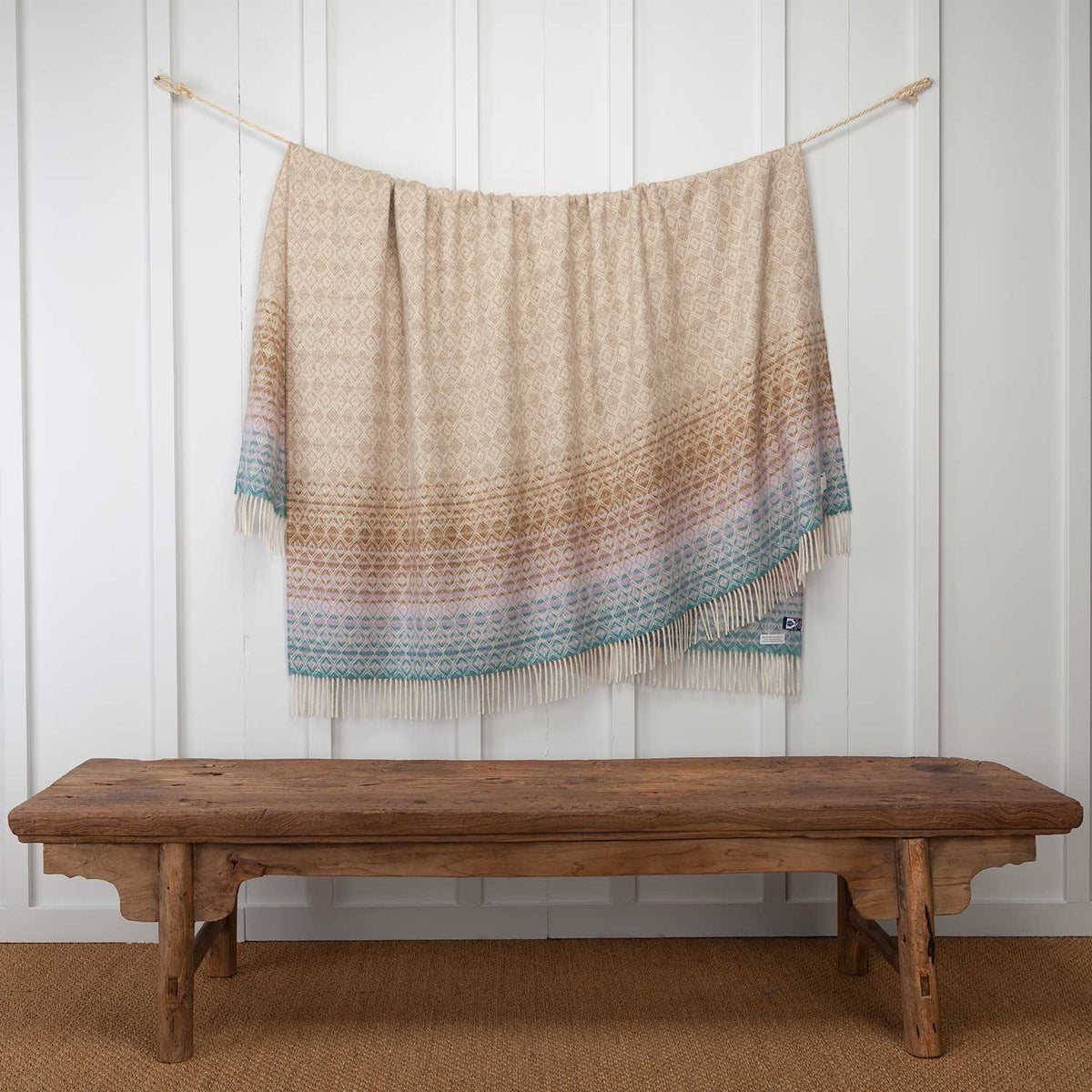 Lambswool throw with diamond pattern and cream fringe, classic beige tones with cool sea blue and lilac tones at end, cream fringe, size is 185 CMS X 140 CMS.