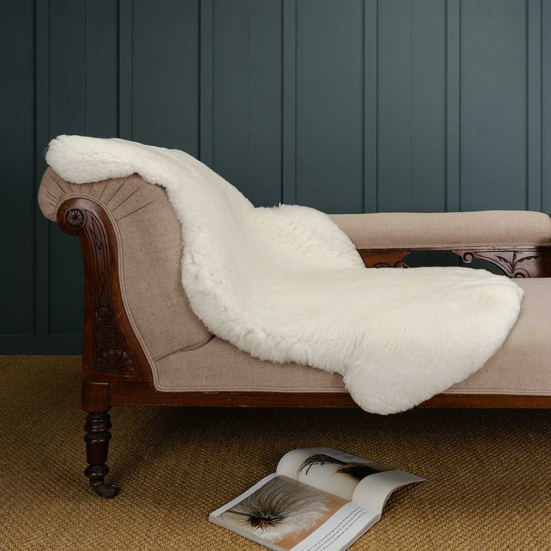 A very large (approximately 115cms long X 79 cms wide Merino wool sheepskin throw in naural white for use in he home, great on furniture or floors. By The Wool Company