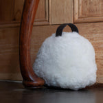 Sheepskin Doorstop in white curly sheepskin with dark brown leather carry handle