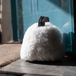 Sheepskin Doorstop in white curly sheepskin with dark brown leather carry handle